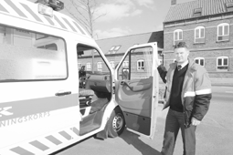 Her ses den nye stationsleder hos Falck i Grenaa, Kim Hansen, der str ved siden af den nyeste Falck-ambulance